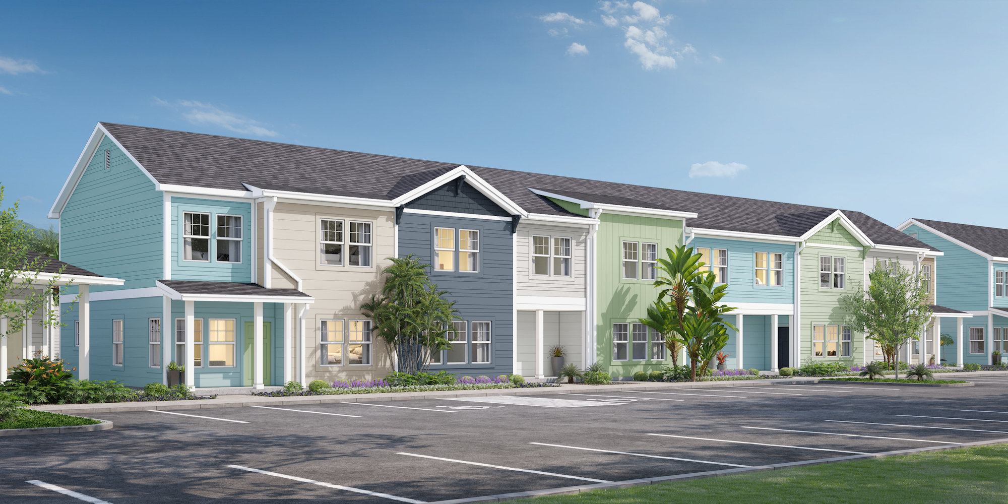 a row of multi-story houses with trees and a parking lot